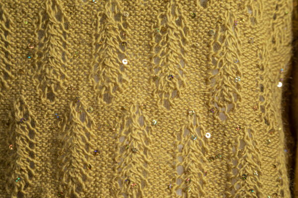 Close up of sparkly sequined mustard knitted Christmas party sweater