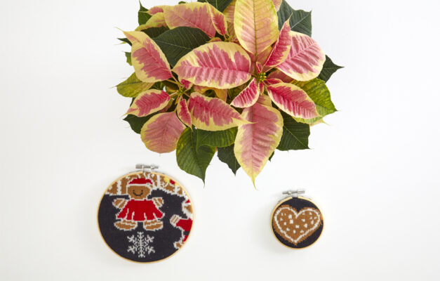 Poinsettia flowers and two embroidery hoops made with Christmas jumper cuts