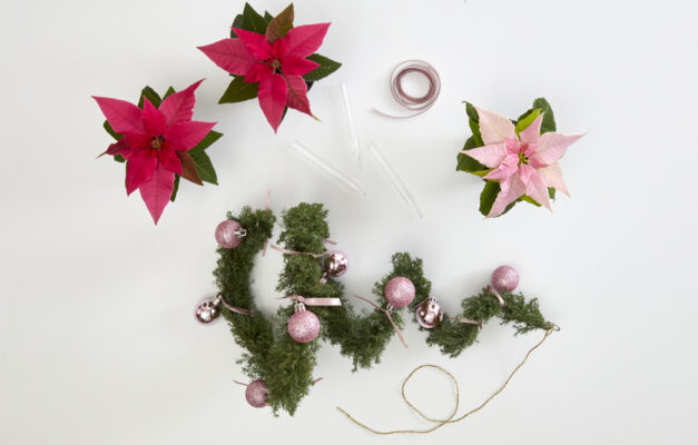 Coiled wire Christmas tree with pink baubles, with poinsettia flowers around