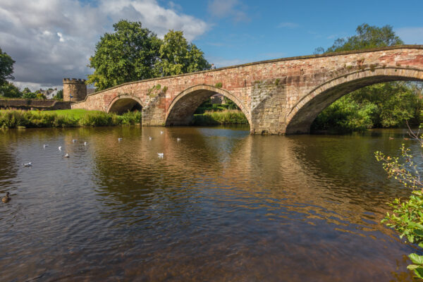 A view of Haddington Nungate bridge over the river in golden sunlight of sunset