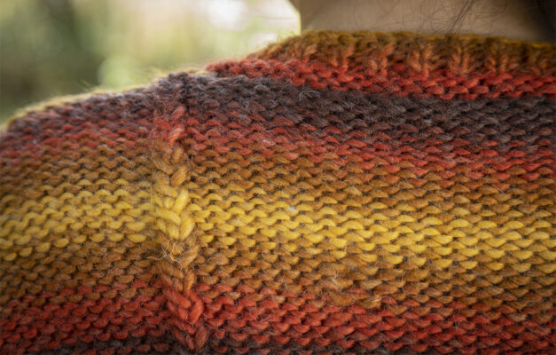 Close up of easy sweater knitting pattern in warm tone stripes