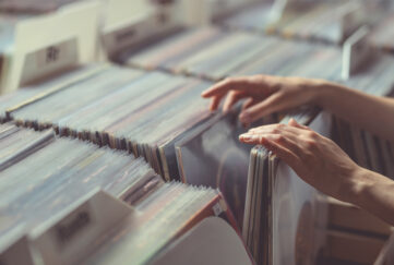 Woman's hand browsing through boxes of vinyl records