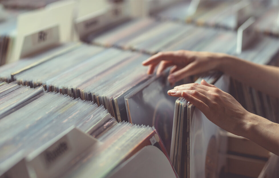 Woman's hand browsing through boxes of vinyl records