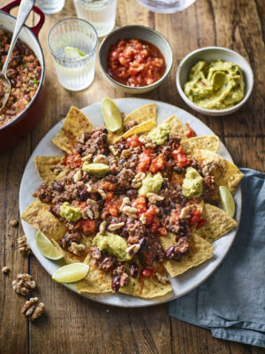Chilli California Walnut nachos plate with side bowls of salsa and guacamole