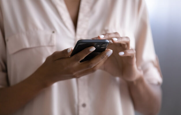 Hands with painted nails holding a smart phone as if to call someone