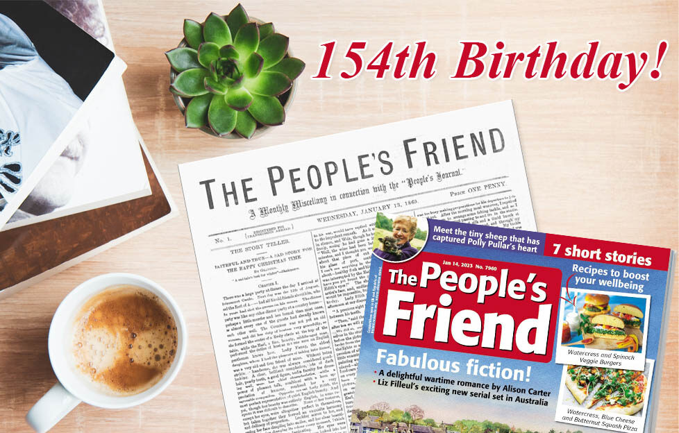 A flatlay of the original first issue of The People's Friend with the current issue on top, next to a coffee, pile of books and succulent