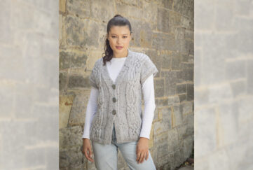 Brown haired woman model wearing a cosy knit celtic pattern gilet in a silver shade