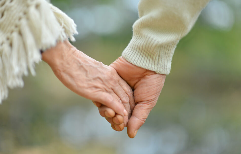 Close up of elderly hands holding hands