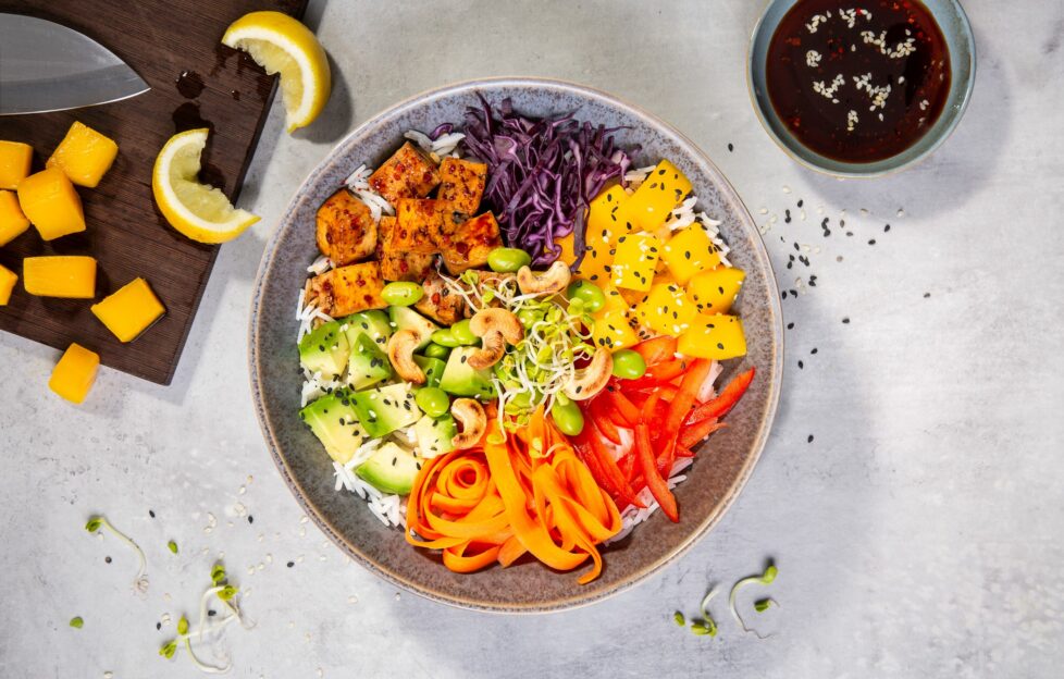 Top down view of rainbow bowl recipe with sections of different coloured foods