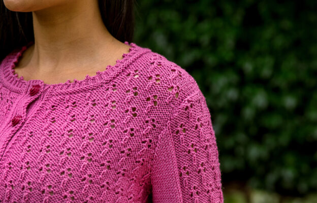 Close up of woman wearing pink lacy cardigan, close up at the shoulder and neck.