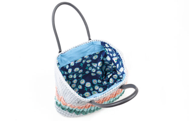 Crochet bag opened up to reveal dark blue floral patterned inside fabric