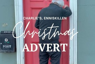 The opening scene from the Charlie's Bar Budget Christmas ad. An elderly man is seen leaving his home with a bunch of flowers. 'Charlie's Enniskillen Christmas Advert' is written in script font across the image.