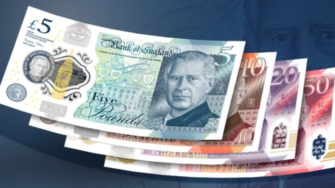 Image feature a five pound note with King Charles' face on it. This note is stacked upon a ten, a 20 and a 50 pound note, also with King Charles' face on them.