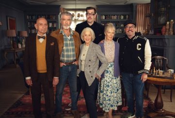 First look at 'The Thursday Murder Club Cast' dressed in character and posing on set with author Richard Osman standing behind them.