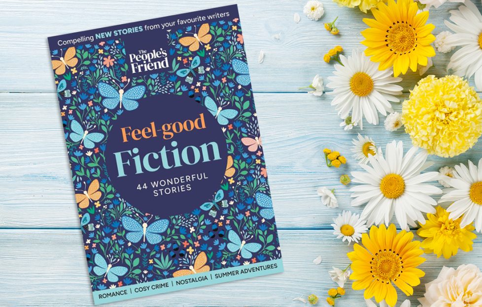 Feel Good Fiction Bookazine cover on a table with daisies