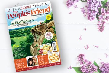 Copy of The People's Friend May 18 issue 2024, on a white table with flowers