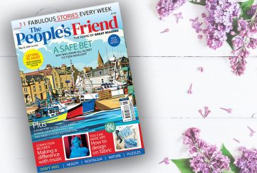A wooden table with a copy of The People's Friend May 25 2024