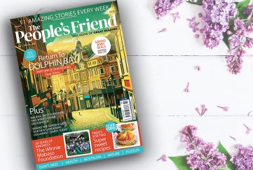 June 1 2024 issue of the People's Friend on a wooden white table with flowers