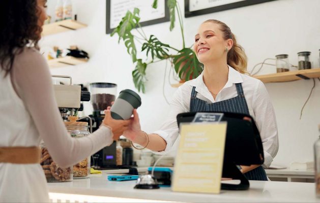 A lady using a reuseable cup in a coffee shop