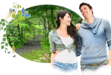 illustration of a young man and young woman side hugging as they walk down a forest path.