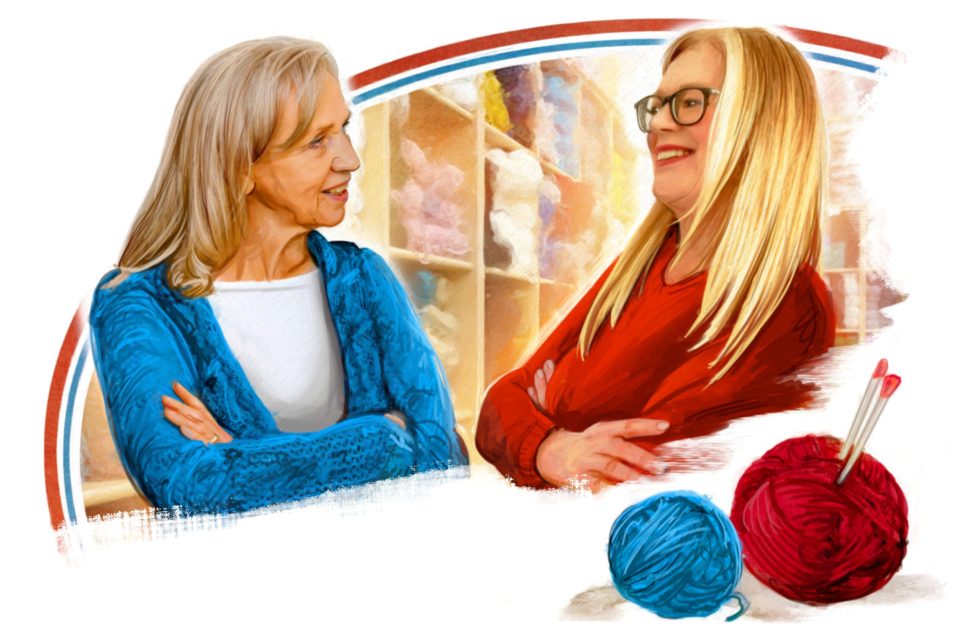 Illustration of two women sitting opposite each other and smiling. They are in a wool shop and are each wearing a knitted jumper. the woman on the left has a blue knitted jumper and the woman on the right has a red knitted jumper. In front of them are two balls of wool, also one blue and one red.