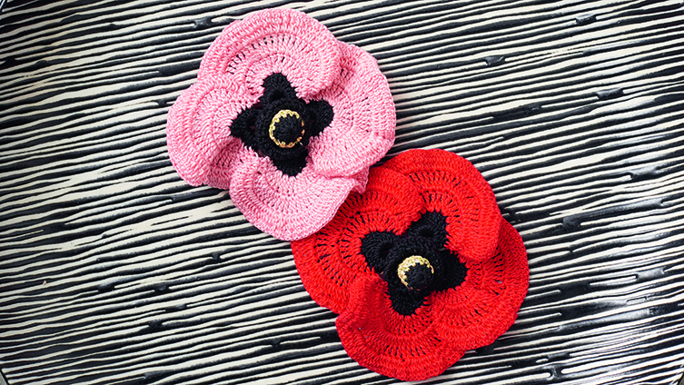 Two poppies, one pink, one red, worked using our free crochet pattern