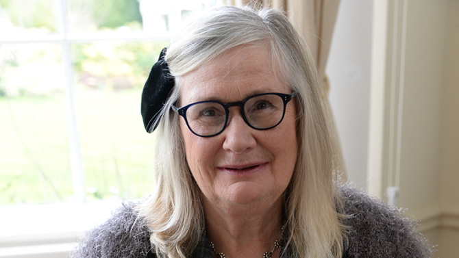 literary agent Caroline Sheldon wearing a purple cardigan and bow in her hair