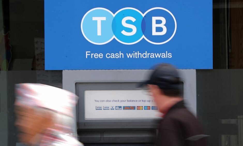 A man uses a TSB cash machine.