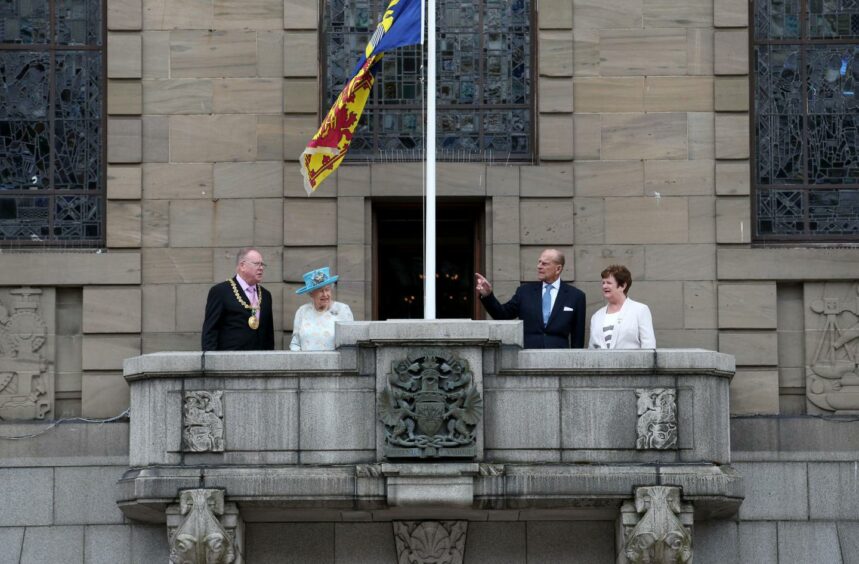 Her Majesty and the Duke of Edinburgh appear on the balcony of Dundee City Chambers with the Lord Provost of Dundee Bob Duncan (left) and his wife Brenda Duncan (right) in 2016.