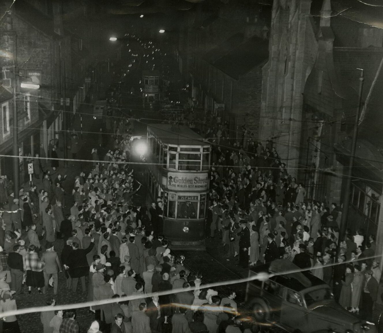 The tram arriving at Lochee Depot surrounded by thousands of people. 