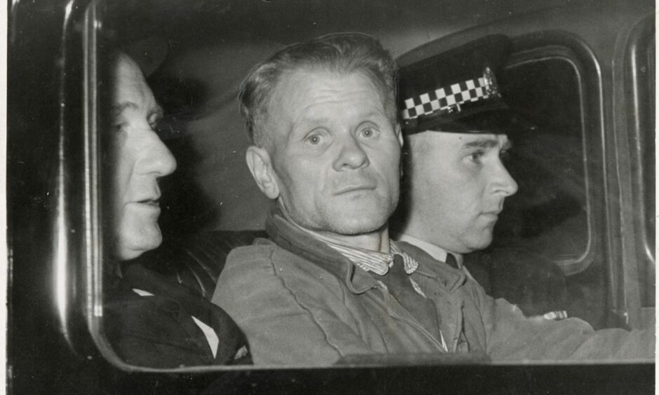 Johnny Ramensky, pictured in the back of a police car, was a conman, safe-cracker, escapologist and Commando was held in Perth. Image: DC Thomson.