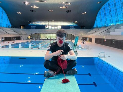 Tom Daley knitting on a diving board (Comic Relief/PA)