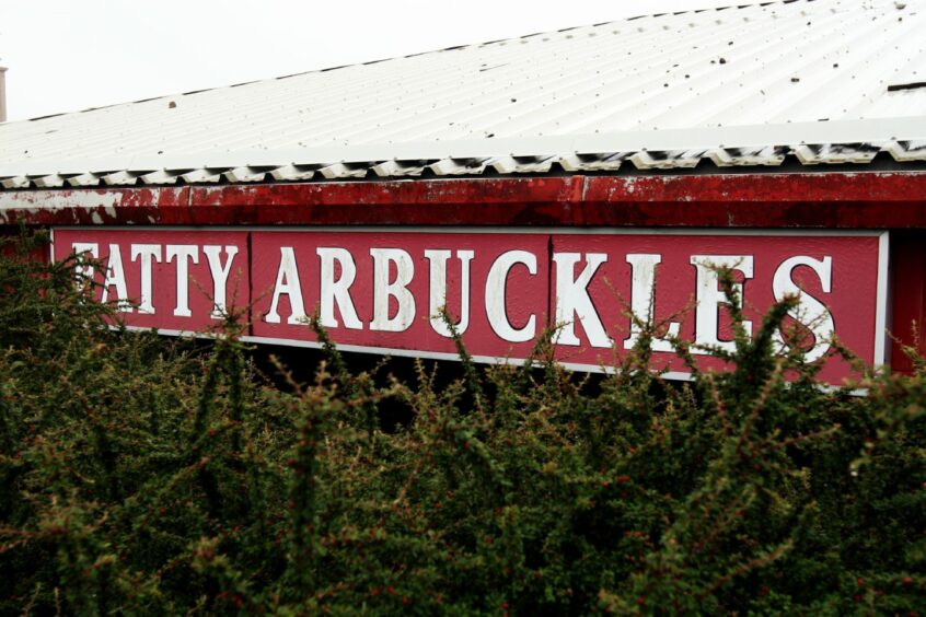 The Fatty Arbuckle's sign almost lost in the undergrowth following its closure.