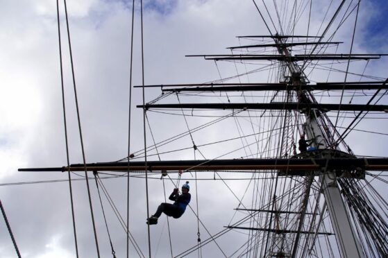 A climber uses the breeches buoy technique to descend from the rigging of the Cutty Sark in Greenwich, south London, at a preview of the Cutty Sark Rig Climb Experience, which opens to the public from Saturday. For the first time since arriving in Greenwich in 1954, visitors to Cutty Sark will be able to climb the famous ship's masts and enjoy views of the Thames and London with urban adventure company Wire and Sky. Gareth Fuller/PA Wire.