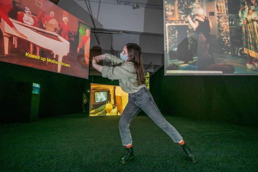 Andi Brogan, a student dancer from Dundee and Angus College, dances next to the Charles Atlas multi-screen film installation.  Kim Cessford/DCT Media.