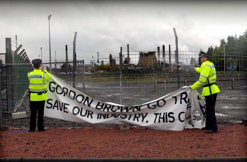 Police clear away the banners outside Grangemouth following a fuel price protest.