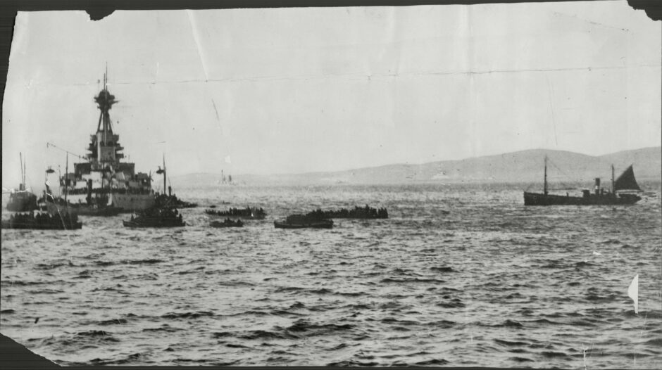 A German battleship sinks as its crew leaves in small boats at Scapa Flow in 1919.