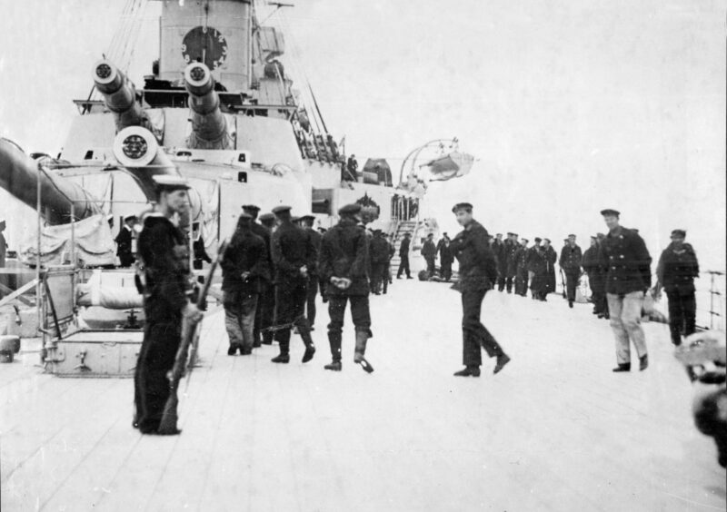 A British Navy ship picks up German sailors after their vessel is scuttled.
