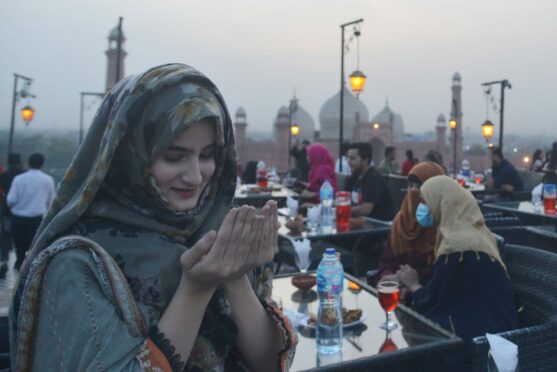 Pakistani staff distribute food among people for breaking their fast at Haveli Restaurant near Historical Badshahi Mosque during the Muslim holy fasting month of Ramadan in Lahore. Islam's holy month of Ramadan-ul-Mubarak is celebrated by Muslims worldwide, marked by fasting, abstaining from food, sex and smoking from dawn to dusk for soul cleansing and strengthening the spiritual bond between them and the Almighty. Muslims enter into a period of discipline and worship: fasting during the day, and praying throughout the day and night. Rana Sajid Hussain/Pacific Press/Shutterstock.