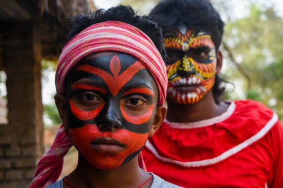 Devotees are seen with various coloured art on their faces, ahead of  the "Bolan" dance on the occasion of Charak festival in the Katwa district, 200 kilometres from Kolkata, India. Charak festival is the Hindu ritual celebrated on the month of chaitra to honour Lord Shiva. Devotees paints various arts on their face and body and perform "Bolan" dance, a Hindu ritualistic dance mainly based from the state of Bengal. Debarchan Chatterjee/NurPhoto/Shutterstock.