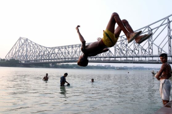 A boy jumps into the Ganga river to cool off as the temperature in Kolkata is likely to reach 40 degrees. The India Meteorological Department (IMD) on Monday issued a heatwave warning over several districts of West Bengal from April 25 to April 28 and asked the residents of the state to avoid prolonged heat exposure. Debajyoti Chakraborty/NurPhoto/Shutterstock.