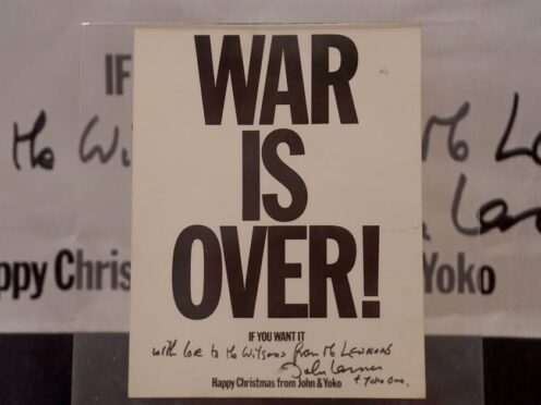 A ‘War is Over’ christmas card, sent in the 1960s by John Lennon and Yoko Ono to the then prime minister Harold Wilson, is unveiled by Tony Bramwell at the Beatles Museum in Liverpool (Martin Rickett/PA)