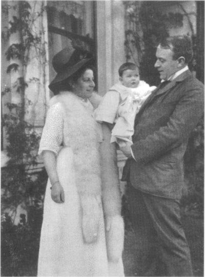 Thomas Andrews holding his baby in his arms between him and his wife
