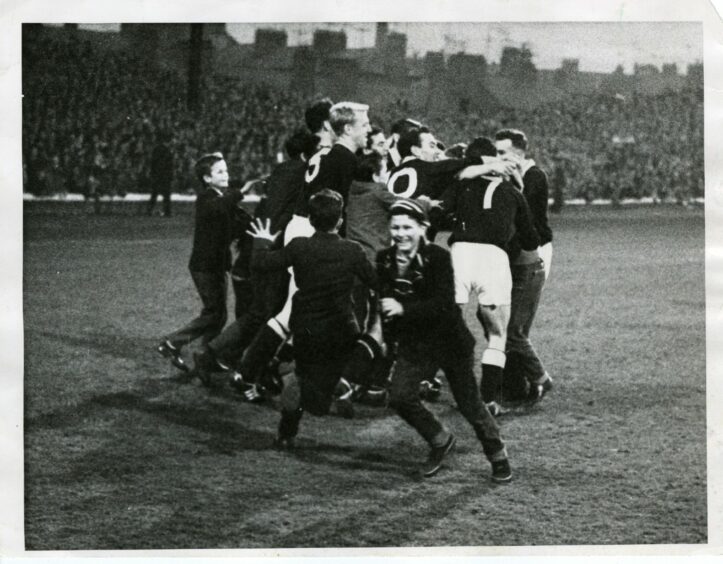 Dundee FC players celebrate on the pitch after their 2-0 win over St Mirren.