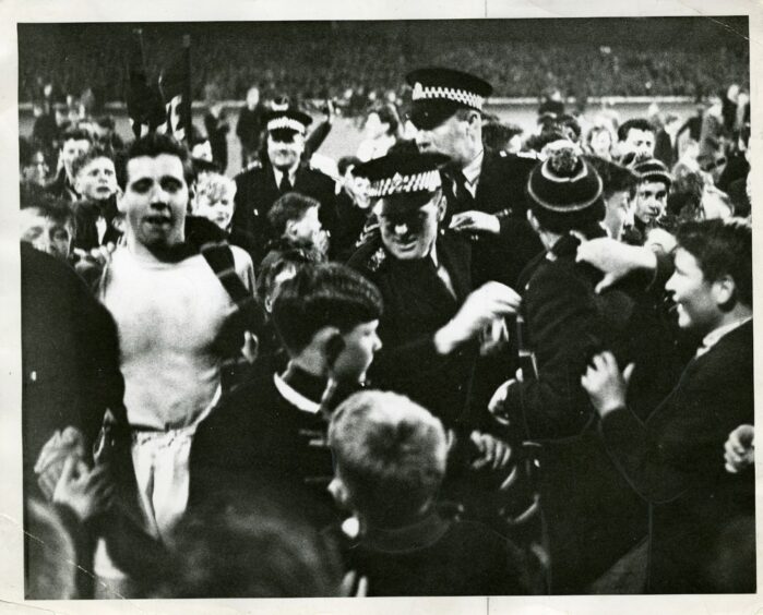 Liney is mobbed by fans at the final whistle after his penalty save.