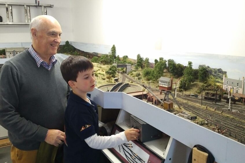 Ian with grandson Kai enjoying the model railway. Supplied by the Moncur family.