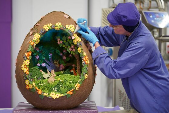 Cadbury World chocolatier Dawn Jenks adds the finishing touches to the Easter-themed chocolate creation at Cadbury World in Birmingham. Jacob King/PA Wire.