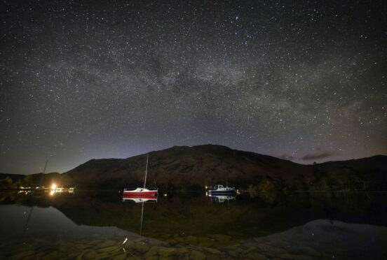 The Milky Way shines during its peak at 2.30am above boats moored on Ullswater in the Lake District, Cumbria. Owen Humphreys/PA Wire.