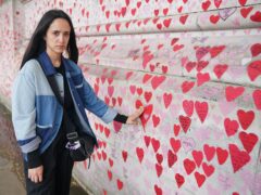 Safiah Ngah, who lost her father to Covid, with the heart she painted for him at the National Covid Memorial Wall in central London (Jonathan Brady/PA)