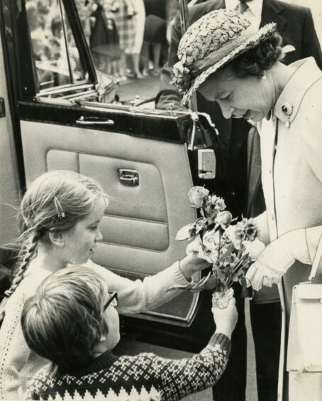 The Queen receiving a posy from eight-year old Shona Borthwick and her six year old brother Alistair Borthwick of Cupar on her visit to St Andrews.